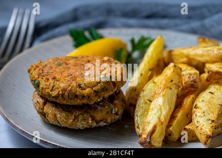 Patties de pois chiches végétaliens avec frites au four. Banque D'Images
