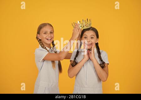 La motivation d'être le meilleur. les petites filles d'imaginer qu'ils sont égoïste princesse. succès récompense. Enfance heureuse amitié. look rétro d'enfants égoïstes. vintage in gold crown. La beauté n'est pas suffisant. Banque D'Images