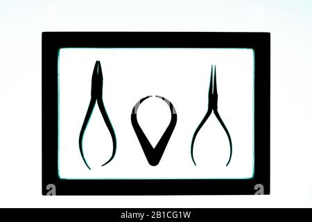 Outils de travail, y compris pinces disposées dans un cadre rétroéclairé avec surbrillance bleue Banque D'Images