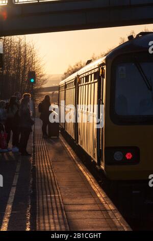 Train aérien de classe 144 paper train se déclinant au coucher du soleil pendant qu'il appelle à Meadowhall Interchange, Sheffield Banque D'Images