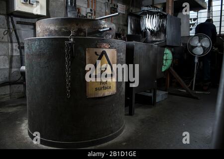 Processus de trempe dans l'usine de couteaux. Four, bain d'huile et vidange Banque D'Images