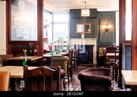 Femme travaillant sur ordinateur portable dans un pub situé à Chiswick High Street, Londres, Angleterre Banque D'Images