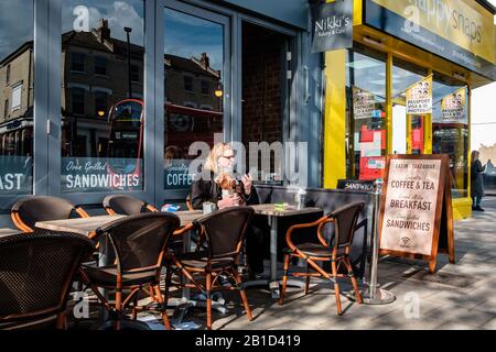 Femme avec son chien aime faire une pause dans un patio urbain d'un café sur Chiswick High Street, Londres, Angleterre Banque D'Images