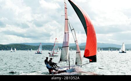 Les enfants qui naviguent dans de petits bateaux colorés et des dinghies pour s'amuser et en compétition. Travail d'équipe par des marins juniors en course sur le lac Macquarie Banque D'Images