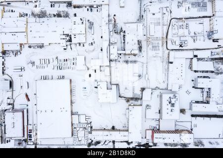 zone industrielle avec bâtiments d'usine et entrepôts couverts de neige. vue aérienne sur le dessus Banque D'Images