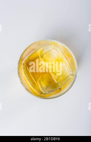 Un verre de whisky avec des supports de glace sur un fond blanc. La vue du haut. Banque D'Images