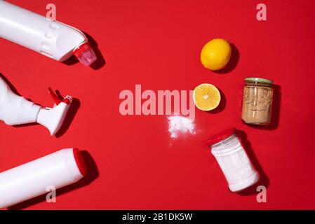 Bicarbonate de soude, poudre de citron et de moutarde contre les produits chimiques ménagers sur fond rouge. Vue de dessus. Espace de copie. Pose plate. Nettoyage efficace et sûr de la maison. Banque D'Images