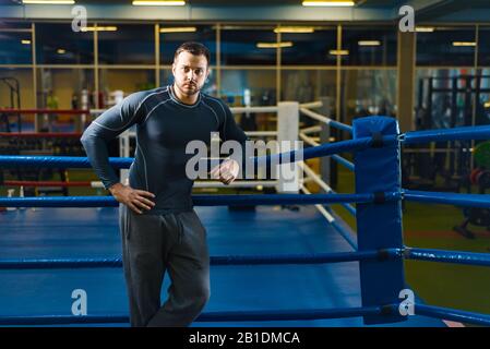 portrait d'un jeune gars de sport dans la salle de gym. l'homme se tient sur le ring de boxe Banque D'Images