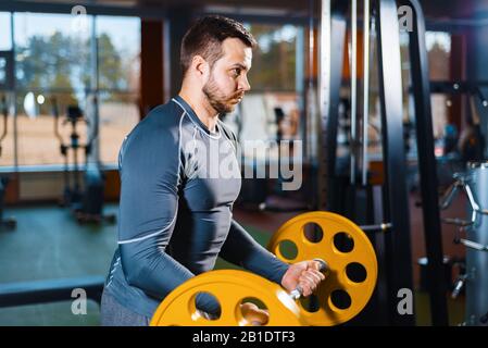 le gars de sport est l'entraînement avec un barbell. l'homme de sport fait le poids dans la salle de gym Banque D'Images