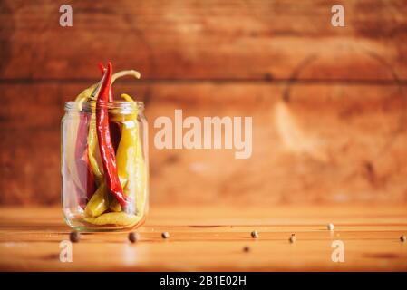 Probiotiques alimentaire contexte. Pickled piment de poivre chaud dans des pots en verre sur fond blanc en bois. Espace de copie. Banque D'Images