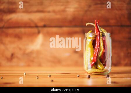 Probiotiques alimentaire contexte. Pickled piment de poivre chaud dans des pots en verre sur fond blanc en bois. Espace de copie. Banque D'Images