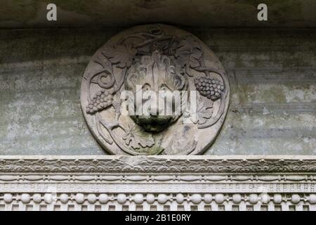 Plaque de tête en pierre sculptée, partie d'une fontaine ornée, Castle Ashby Gardens, Northamptonshire, Royaume-Uni Banque D'Images