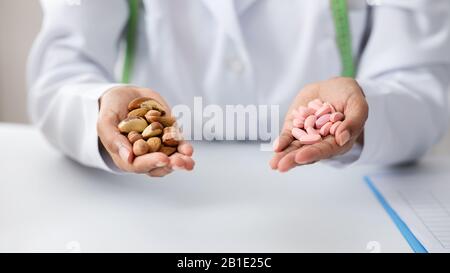 Gros plan de l'otriologue tenant une poignée de noix et de pilules Banque D'Images