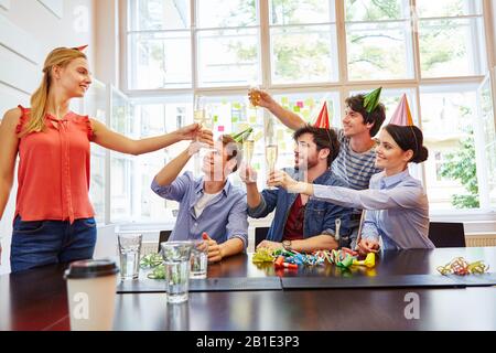 Équipe de démarrage réussie avec du vin mousseux au bureau Banque D'Images