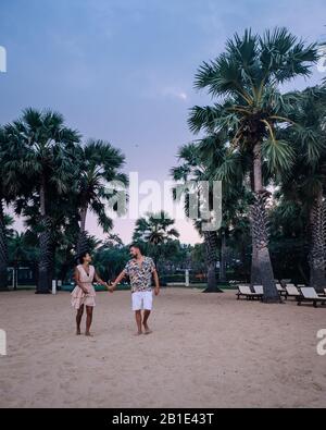 Couple détendez-vous sur la plage de Pattaya Thaïlande Jomtien plage avec des clubs de plage et des restaurants Banque D'Images