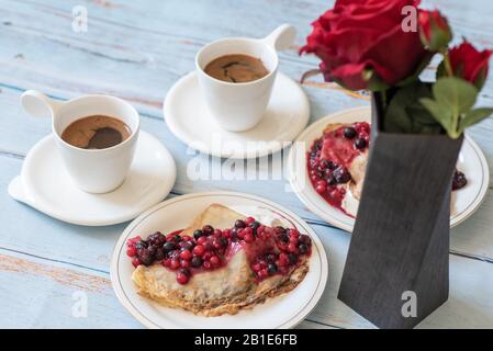 petit déjeuner avec deux tasses de café et crêpes aux baies Banque D'Images