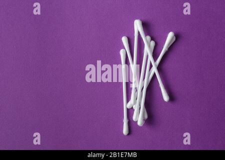 Ecouvillons en coton blanc en plastique sur fond violet vif Banque D'Images