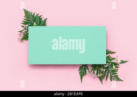 Bannière en fleurs et feuilles avec carte en papier sur fond rose. Maquette. Concept de ressort Banque D'Images