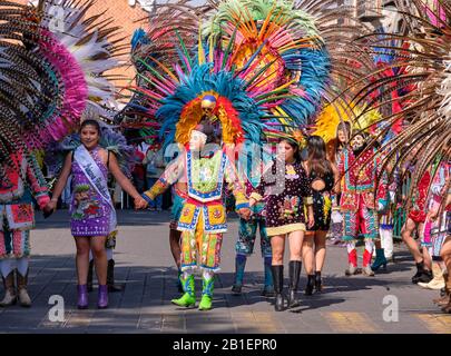 Gamme de danseurs portant le masque avec des visages et des plumes, une partie d'une Portée de Huehues se présentant dans des costumes mexicains traditionnels au Carnaval de Tlaxcala. Banque D'Images