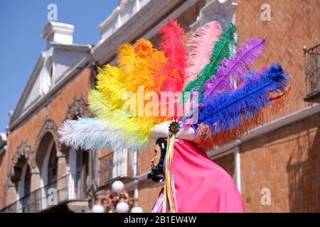 Profil de danseuse avec chapeau de plume de couleur arc-en-ciel faisant partie D'une Portée de Huehues dans les costumes mexicains traditionnels au Carnaval de Tlaxcala. Banque D'Images