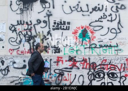 Beyrouth, Liban. 25 février 2020: Un piéton passe devant une barricade murale protégeant le Parlement libanais qui a été couverte par des graffitis par des manifestants anti-gouvernementaux faisant campagne contre la corruption du gouvernement et la crise économique au Liban. Les manifestants se sont affrontés avec les forces de sécurité libanaises à Beyrouth pour tenter de mettre fin à un vote de confiance au parlement sur le nouveau cabinet qu'ils disent ne répond pas à leurs exigences et ne peuvent pas sauver le Liban de la catastrophe économique.crédit: Amer ghazzal/Alay Live News Banque D'Images