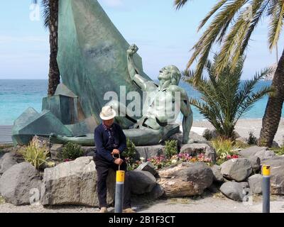 Rêvant d'ANCIENS JOURS la Heradurra, Almuñécar, Granada Province, Espagne 2017 - un vieil homme se reflète sur les temps anciens près de la statue qui commémore le naufrage au large de 25 des 28 vallées de l'Armada espagnole . Environ 5000 personnes ont perdu la vie en une seule journée. La statue sert également de monument à tous ceux qui vont avoir perdu la vie en mer. Banque D'Images