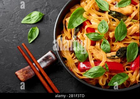 Nouilles thaï Drunken ou Pad Kee Mao dans un bol noir sur fond d'ardoise sombre. Les Nouilles dunken sont un plat de cuisine thaïlandaise avec Nouilles de riz, viande de poulet, basi Banque D'Images