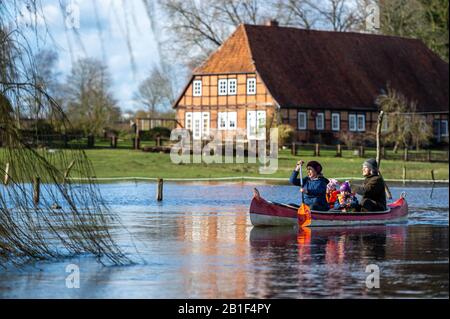 25 février 2020, Basse-Saxe, Klein Bünstorf: Une famille fait du canoë sur l'Ilmenau. La rivière a inondé les pâturages adjacents. Plusieurs eaux de la Basse-Saxe ont débordé leurs banques. Photo: Philipp Schulze/Dpa Banque D'Images