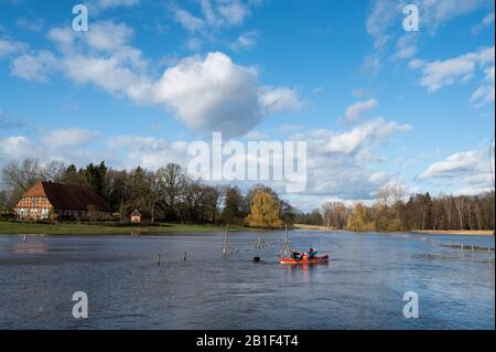 25 février 2020, Basse-Saxe, Klein Bünstorf: Une famille fait du canoë sur l'Ilmenau. La rivière a inondé les pâturages adjacents. Plusieurs eaux de la Basse-Saxe ont débordé leurs banques. Photo: Philipp Schulze/Dpa Banque D'Images