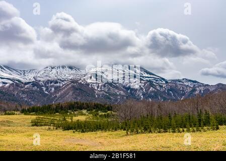 Paysages ruraux. Chaîne de montagnes vallonnées, champ de terres agricoles et ciel bleu avec nuages blancs dans une belle journée ensoleillée dans le printemps de pays de haute latitude Banque D'Images