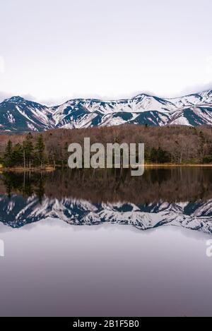 Le Deuxième Lac De Shiretoko Goko Cinq Lacs. Chaîne de montagnes vallonnés et bois au printemps. Paysage de beauté naturelle de pays de haute latitude Banque D'Images