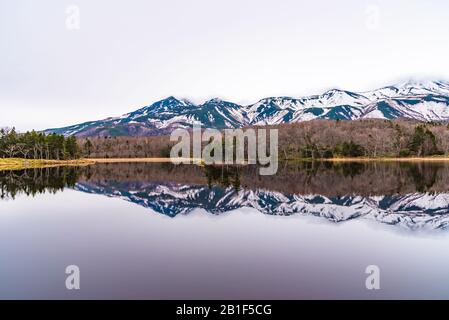 Le Deuxième Lac De Shiretoko Goko Cinq Lacs. Chaîne de montagnes vallonnés et bois au printemps. Paysage de beauté naturelle de pays de haute latitude Banque D'Images