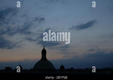 Les dômes de l'église dans les nuages gris et le ciel bleu clair d'avant l'aube avec une silhouette des trois dômes de Chiesa di Sant'Alessandro à Zebedia, ville de Milan Banque D'Images