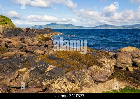 Vue depuis les rochers de Hog's Head couverts de rivage vers Ballinskelligs Bay et les montagnes environnantes. Comté De Kerry, Irlande. Banque D'Images