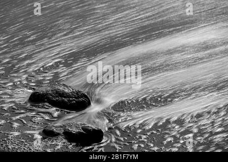 Pierres lavées autour avec de l'eau dans le sable noir de lave, noir et blanc, la Palma, îles Canaries, Espagne Banque D'Images