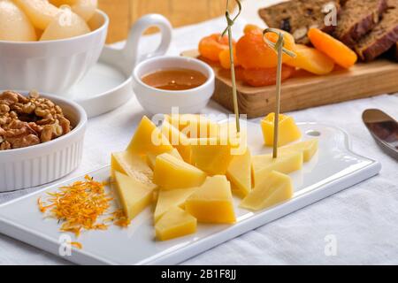 Ensemble de divers hors-d'œuvre pour le vin - fromage, noix, abricots secs, miel et poire en conserve Banque D'Images