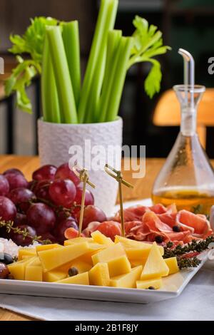 Vue rapprochée de divers hors-d'œuvre pour le vin - fromage, prosciutto, raisin, olives, noix et céleri Banque D'Images