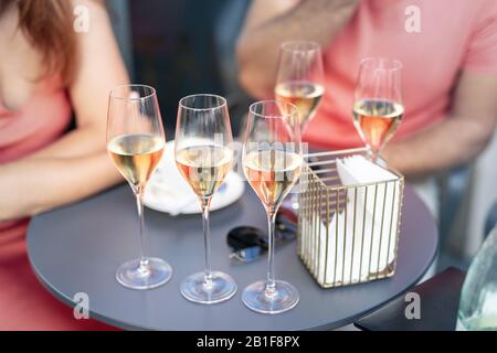 Table de gros plan avec de nombreux verres remplis de champagne blanc Prosecco lors de l'événement de fête à l'extérieur. Les gens qui s'amusent aiment boire de l'alcool Banque D'Images