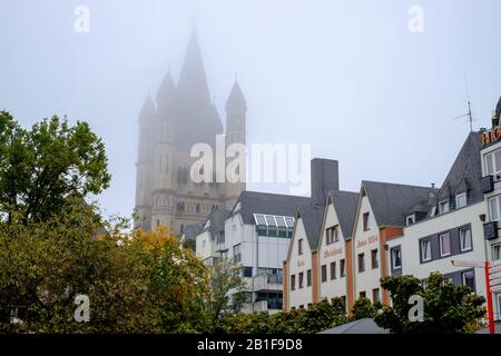 La Grande église Saint-Martin, un monument majeur avec des tours caractéristiques, disparaît presque dans la brume. Les maisons typiques sont au premier plan. Banque D'Images