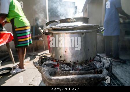 Marmite en argent vapeur au charbon de bois contre le soleil, cuisine extérieure au Mozambique Banque D'Images