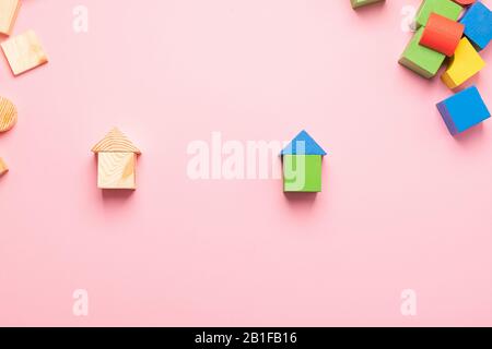 Jouets en bois pour enfants sur un fond rose concept zéro ouest. Petites maisons le concepteur de développer des cubes de couleur . Espace de copie de cadre horizontal. À Banque D'Images