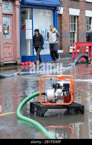 Shrewsbury, Shropshire, Royaume-Uni - mardi 25 février 2020 - les amateurs de shopping s'attènent sur les inondations, les pompes et les tuyaux dans le centre-ville. La rivière Severn culminera plus tard aujourd'hui et un grave avertissement d'inondation est actuellement en vigueur pour Shrewsbury. Photo Steven May / Alay Live News Banque D'Images