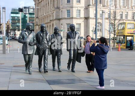 Les touristes posent avec la statue en bronze des beatles à côté du mersey à liverpool angleterre Banque D'Images