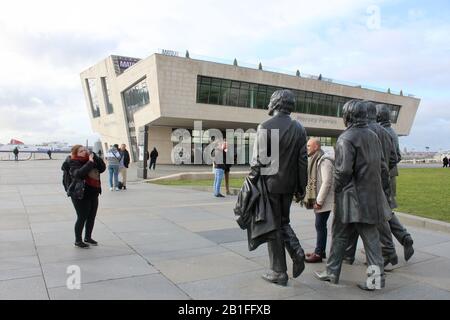 Les touristes posent avec la statue en bronze des beatles à côté du mersey à liverpool angleterre Banque D'Images