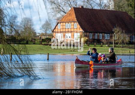 25 février 2020, Basse-Saxe, Klein Bünstorf: Une famille fait du canoë sur l'Ilmenau. La rivière a inondé les pâturages adjacents. Plusieurs eaux de la Basse-Saxe ont débordé leurs banques. Photo: Philipp Schulze/Dpa Banque D'Images