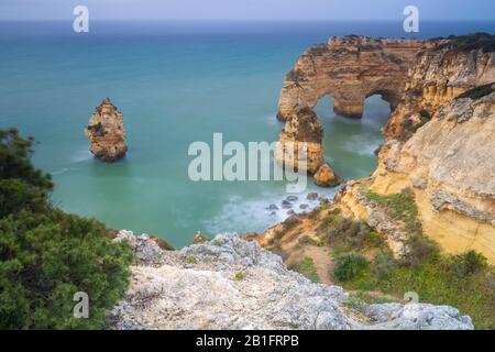 Vue sur les célèbres arches naturelles de Praia da Marinha. Caramujeira, Lagoa, Algarve, Portugal, Europe. Banque D'Images