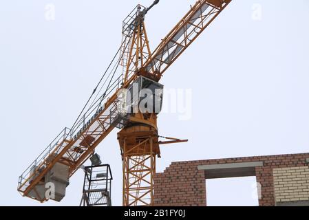 22-02-2020 Russie Syktyvkar. La grue de tour travaille sur un site de construction contre le ciel. Vue rapprochée de la cabine du conducteur de la grue. Banque D'Images