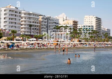 Touristes sur la plage à Finikoudes, Larnaca, Chypre. Banque D'Images