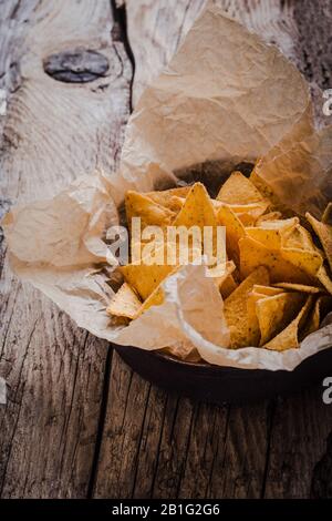 Chips de tortilla dans un bol d'artisanat sur une table en bois rustique, gros plan Banque D'Images