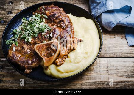 Osso buco avec gremolata, condiment de hacher le cilantro, l'ail, et le zeste de citron, servi avec polenta. Cuisine italienne traditionnelle Banque D'Images